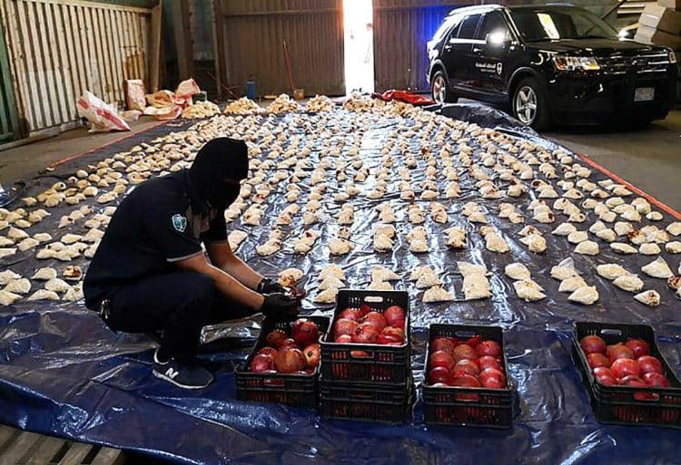 FILE - In this Friday, April 23, 2021 file photo, released by Saudi Press Agency, a Saudi custom officer opens imported pomegranates, as customs foiled an attempt to smuggle over 5 million pills of an amphetamine drug known as Captagon, which they said came from Lebanon, at Jiddah Islamic Port, Saudi Arabia. Lebanon called on Saudi Arabia Monday to reconsider its decision to ban Lebanese produce from entering the oil-rich kingdom over drug smuggling vowing to take strict measures to prevent such acts and investigate the case. (Saudi Press Agency via AP, File)
